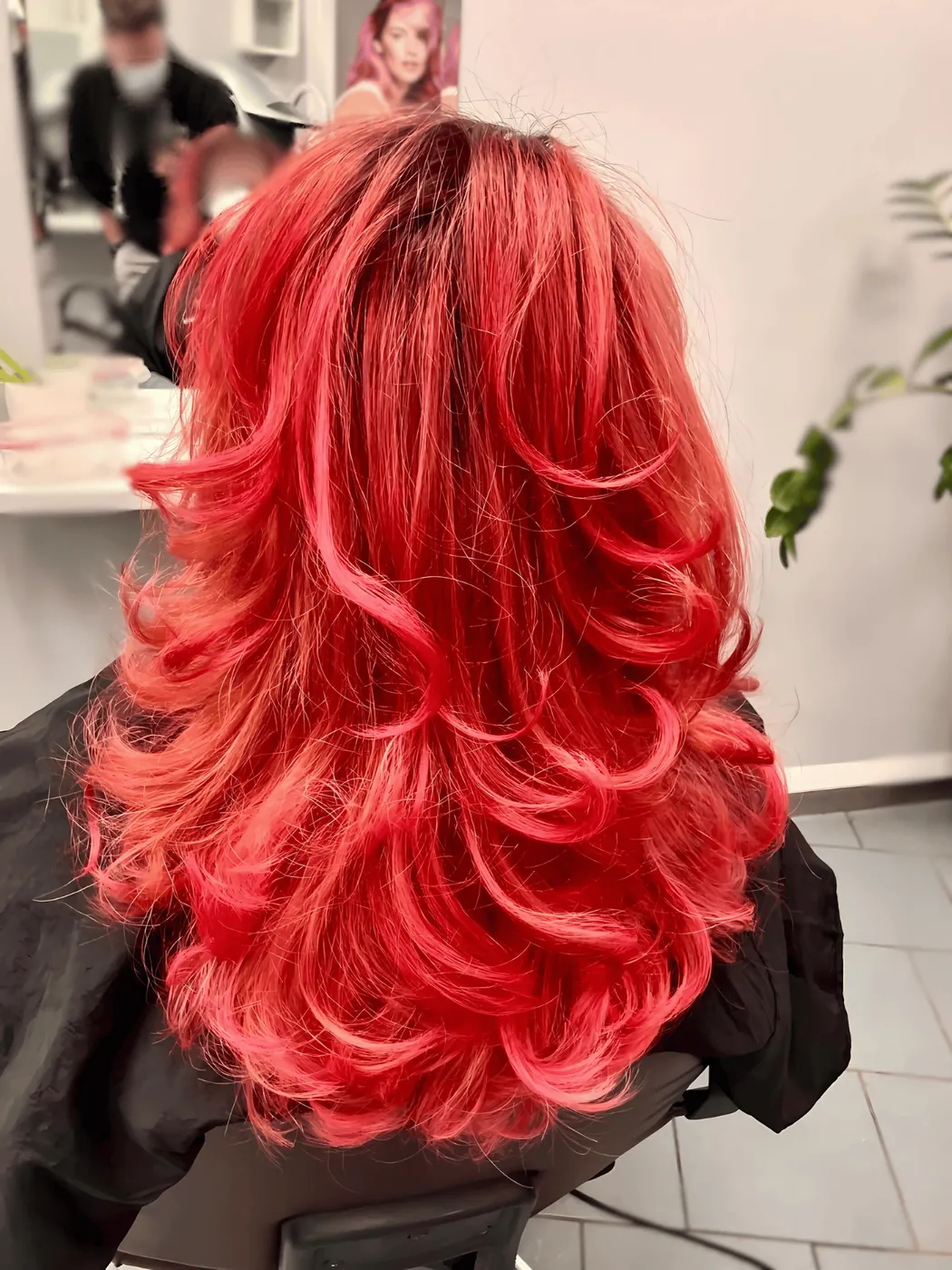 Kundin mit leuchtend roten, lockigen Haaren im Salon Success by Dennes